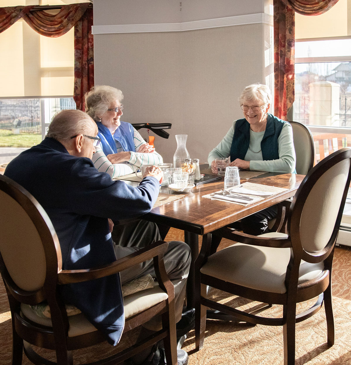 smiling residents in sunlit dining area